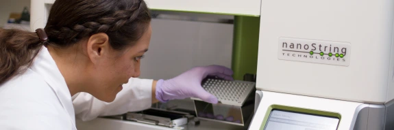 Laboratory Technician loading nanostring instrument